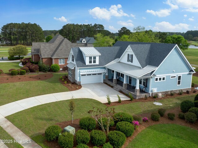 9307 Old Salem Way, Calabash, NC 28467 - view of front facade featuring covered porch, concrete driveway, a garage, a front lawn, and metal roof