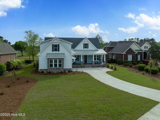9307 Old Salem Way, Calabash, NC 28467 - modern farmhouse with board and batten siding, driveway, a porch, and a front lawn