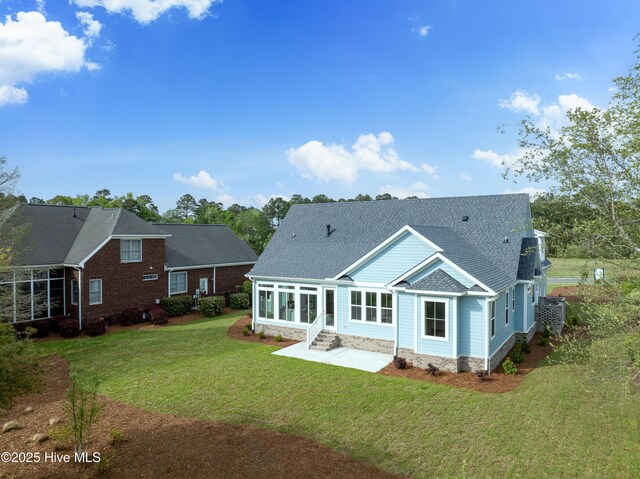 9307 Old Salem Way, Calabash, NC 28467 - rear view of house with a sunroom, a lawn, a patio area, roof with shingles, and entry steps