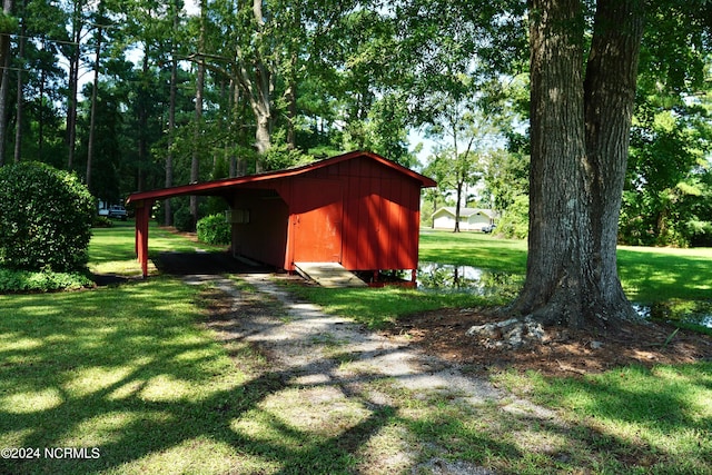 view of outbuilding with a yard and a water view