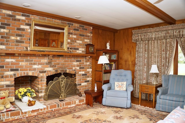 living room featuring wood-type flooring, ornamental molding, beamed ceiling, a fireplace, and wooden walls