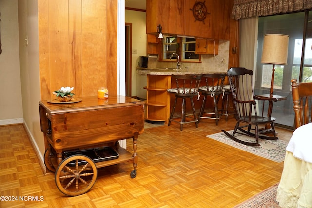 bar with dishwasher, decorative backsplash, crown molding, sink, and light parquet floors