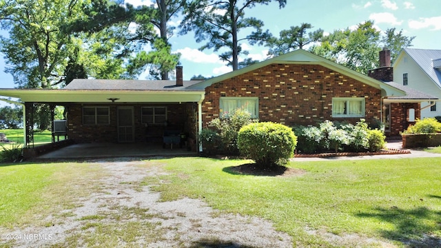 view of front of property with a front yard and a carport