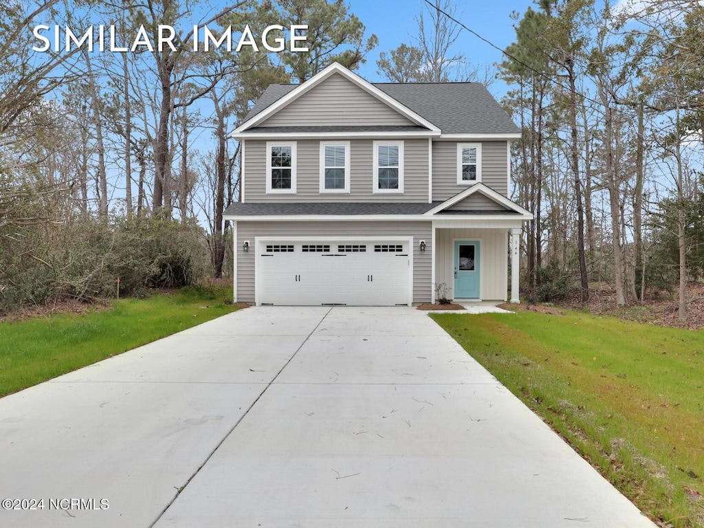 view of front of property featuring a front yard and a garage