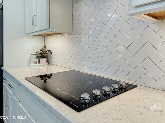 283 Golfview Ct SW, Supply, NC 28462 - kitchen with light stone counters, backsplash, and black electric cooktop