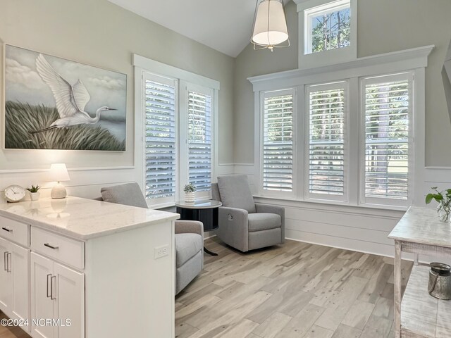 interior space featuring lofted ceiling and light hardwood / wood-style floors