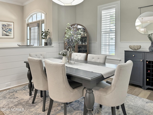 dining room featuring crown molding, a healthy amount of sunlight, a chandelier, and light hardwood / wood-style floors