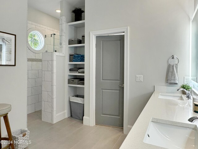 bathroom with a tile shower and vanity