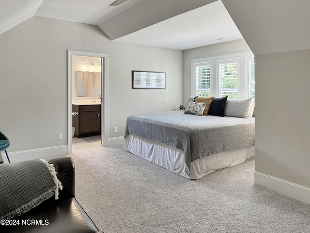 carpeted bedroom with vaulted ceiling and ensuite bathroom