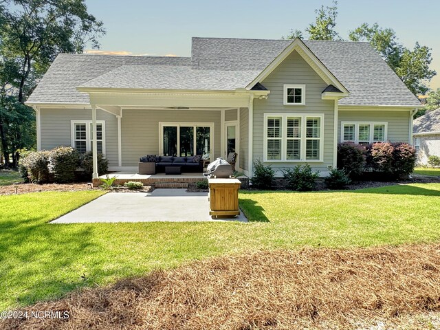 back of house with an outdoor living space, a yard, and a patio