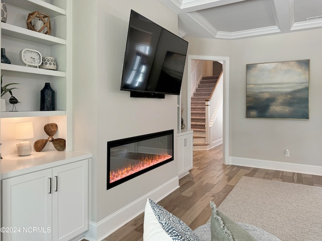 living room featuring light wood-type flooring, coffered ceiling, and crown molding