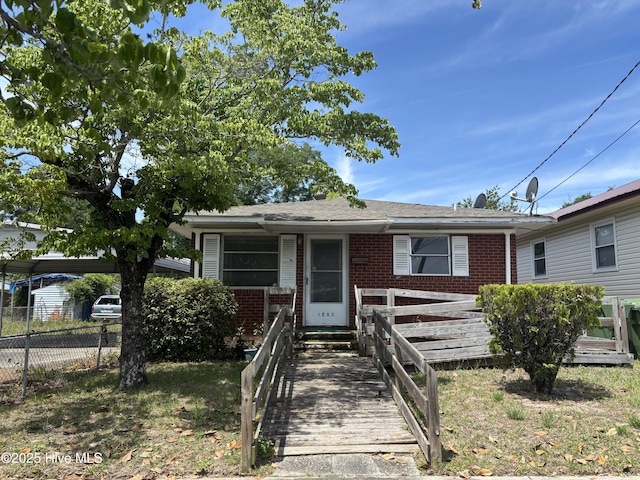 1208 S 9th St, Wilmington, NC 28401 - view of front facade featuring brick siding, a carport, and a shingled roof