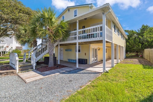 view of front of home featuring a front lawn, stairway, a patio area, and fence