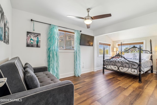 bedroom with a ceiling fan, dark wood-style flooring, vaulted ceiling, and baseboards