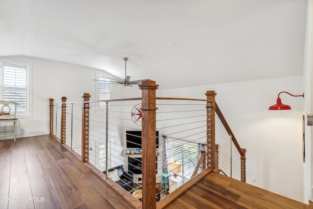 hallway featuring lofted ceiling, a healthy amount of sunlight, an upstairs landing, and wood finished floors