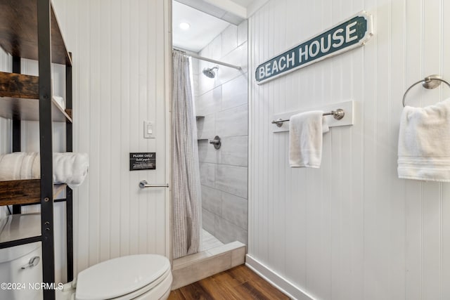 bathroom featuring a stall shower, wood finished floors, and toilet