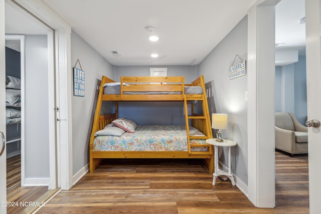 bedroom with recessed lighting, visible vents, baseboards, and wood finished floors