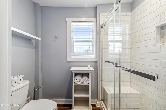 full bath with baseboards, a shower stall, and toilet