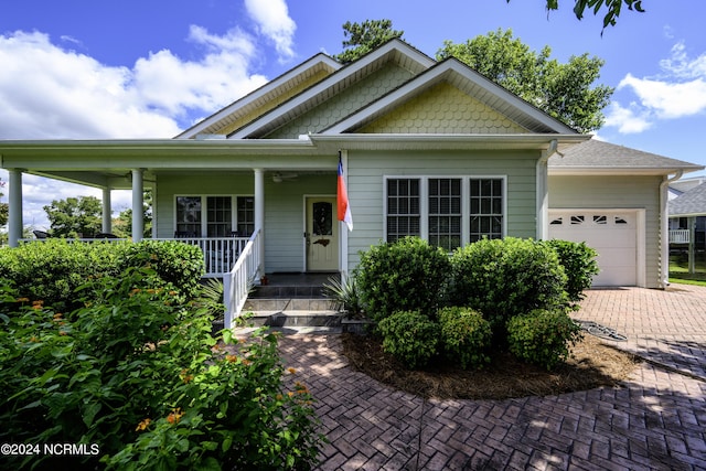 view of front of property with covered porch, decorative driveway, and a garage