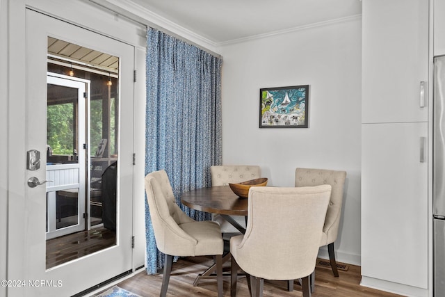 dining area with hardwood / wood-style floors and crown molding