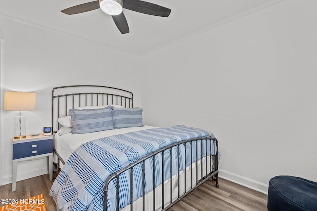 bedroom with crown molding, hardwood / wood-style floors, and ceiling fan