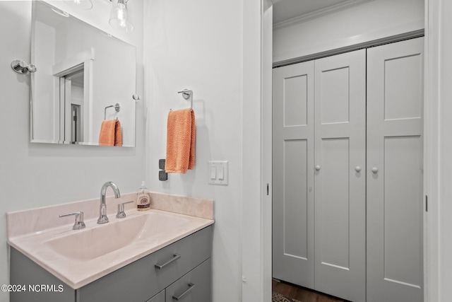 bathroom featuring vanity, hardwood / wood-style flooring, and crown molding