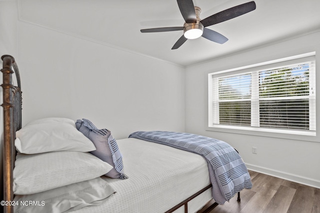 bedroom featuring ceiling fan, crown molding, and hardwood / wood-style flooring