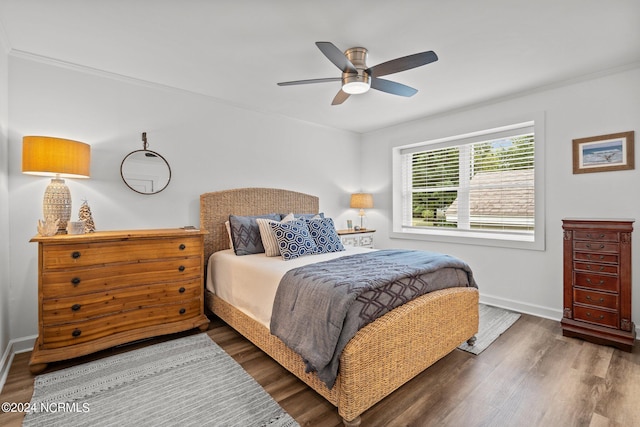 bedroom with ceiling fan, dark wood-type flooring, and ornamental molding