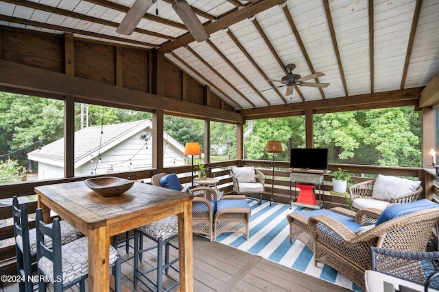 sunroom / solarium with ceiling fan and vaulted ceiling with beams