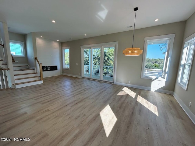 unfurnished living room featuring light hardwood / wood-style floors and a healthy amount of sunlight