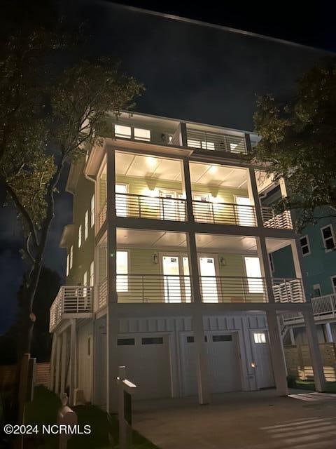 property at twilight featuring concrete driveway and an attached garage