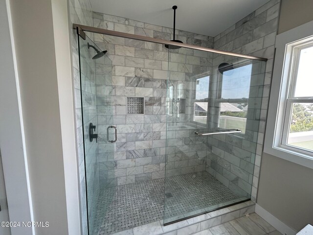 bathroom featuring a shower with door