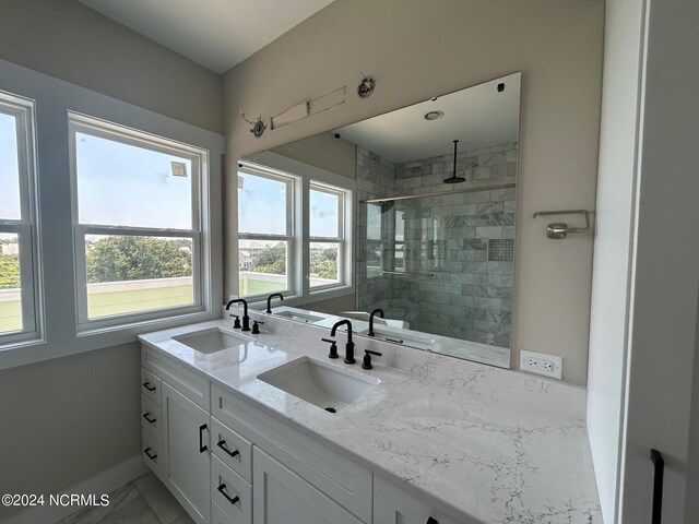 bathroom with vanity and a tile shower