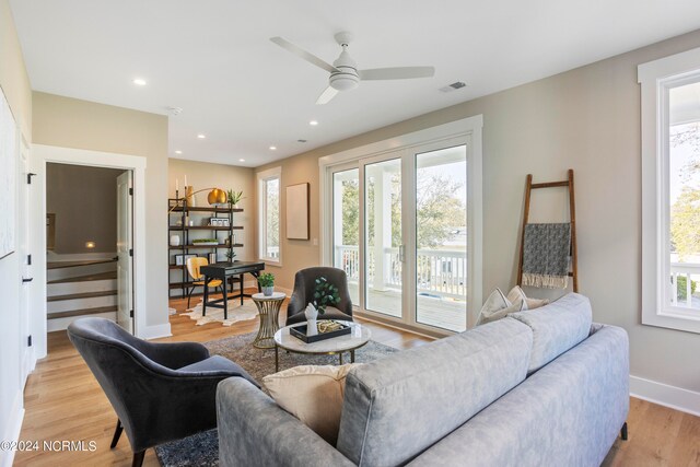 living room featuring ceiling fan, light hardwood / wood-style floors, and plenty of natural light