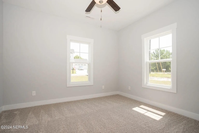 carpeted empty room featuring ceiling fan and a healthy amount of sunlight