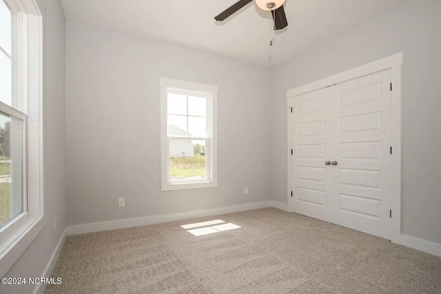 unfurnished bedroom with ceiling fan, a closet, and carpet