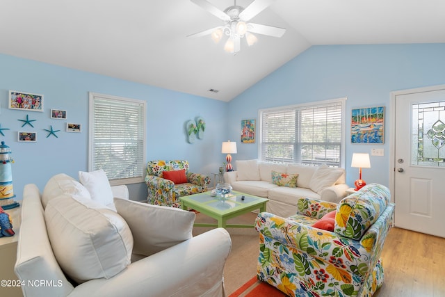 living room with vaulted ceiling, light wood finished floors, visible vents, and a wealth of natural light