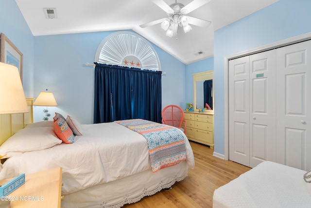 bedroom featuring a closet, light hardwood / wood-style floors, lofted ceiling, and ceiling fan