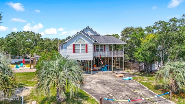 back of house featuring driveway, covered porch, and a carport