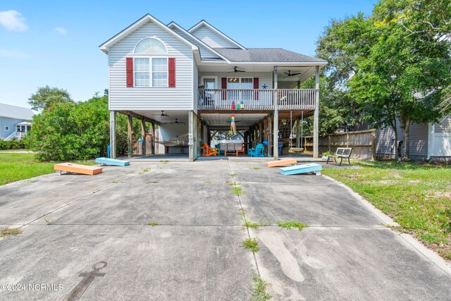 rear view of house with a yard, ceiling fan, and a carport