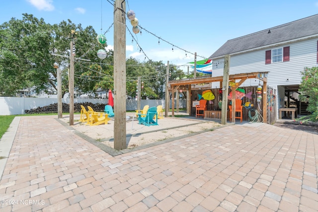 view of patio featuring a fire pit, fence, and a playground