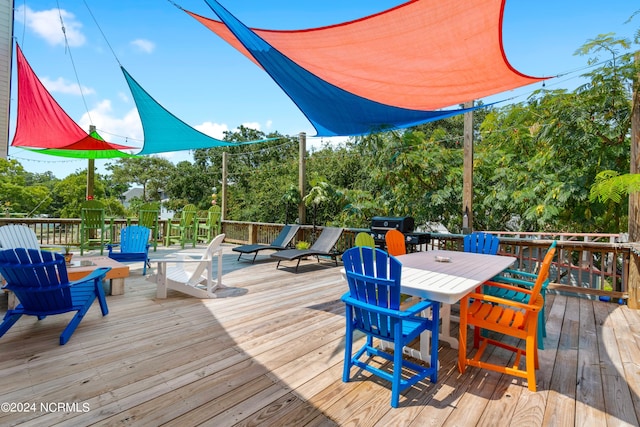 wooden deck featuring grilling area and outdoor dining space