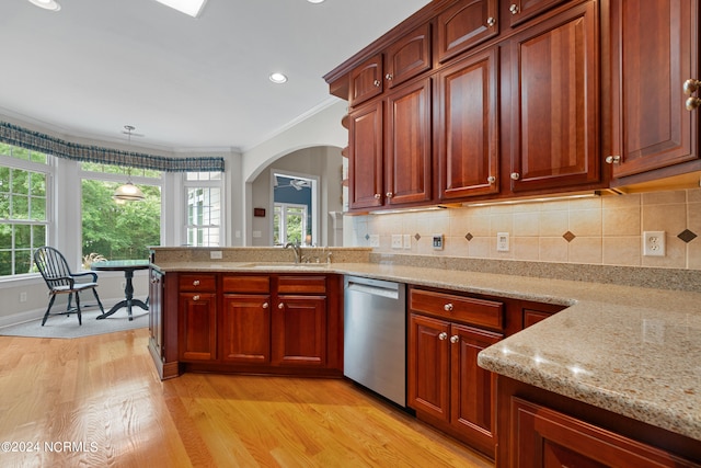 kitchen with dishwasher, light wood-style floors, a sink, and decorative backsplash