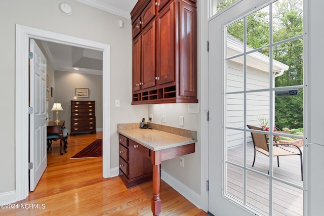 bar featuring light wood finished floors, baseboards, and ornamental molding