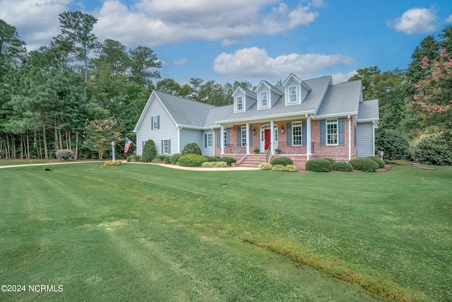 cape cod house featuring a front lawn and covered porch