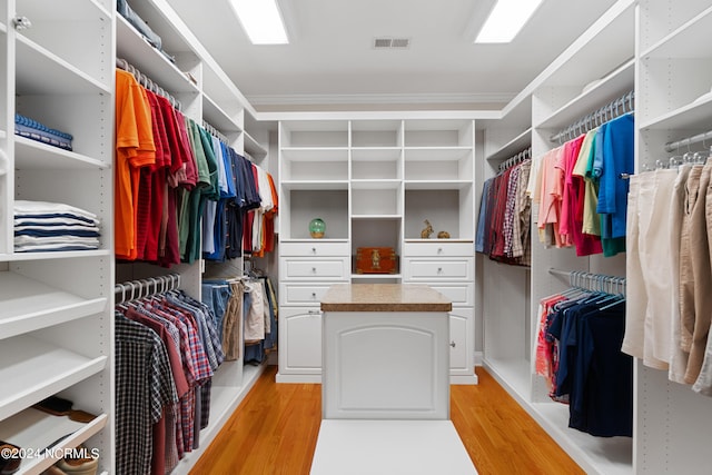 walk in closet with light wood-type flooring and visible vents