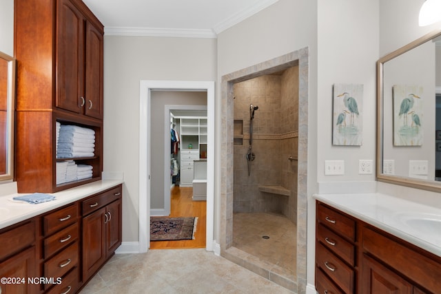 full bathroom with ornamental molding, two vanities, walk in shower, and a walk in closet