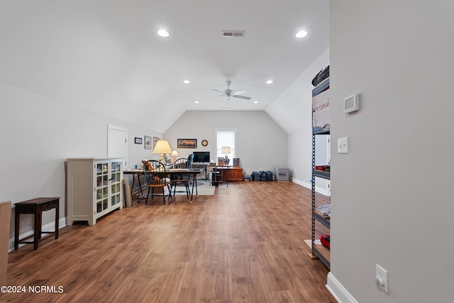 office space featuring vaulted ceiling, wood finished floors, visible vents, and baseboards