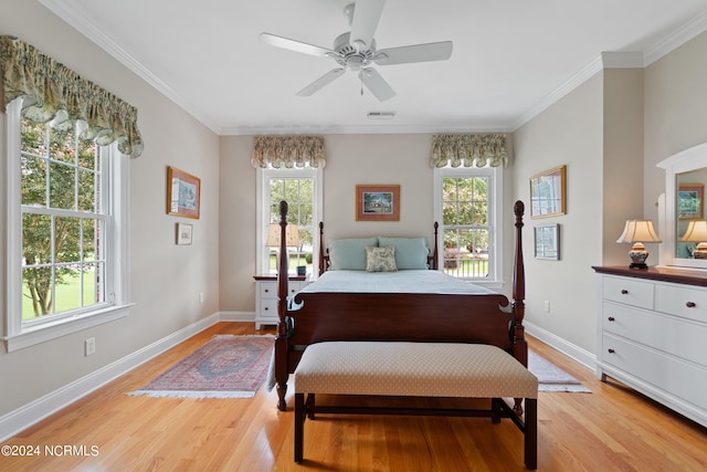 bedroom with light wood-type flooring, multiple windows, and crown molding