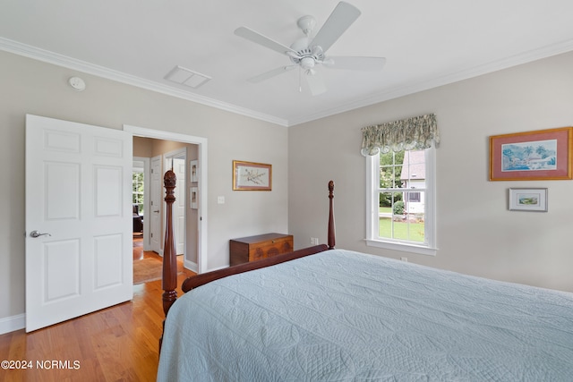 bedroom featuring light wood-type flooring, ornamental molding, and ceiling fan